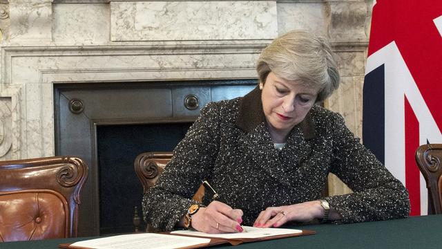 Theresa May signe la lettre déclenchant le Brexit. [EPA/Keystone - Jay Allen]
