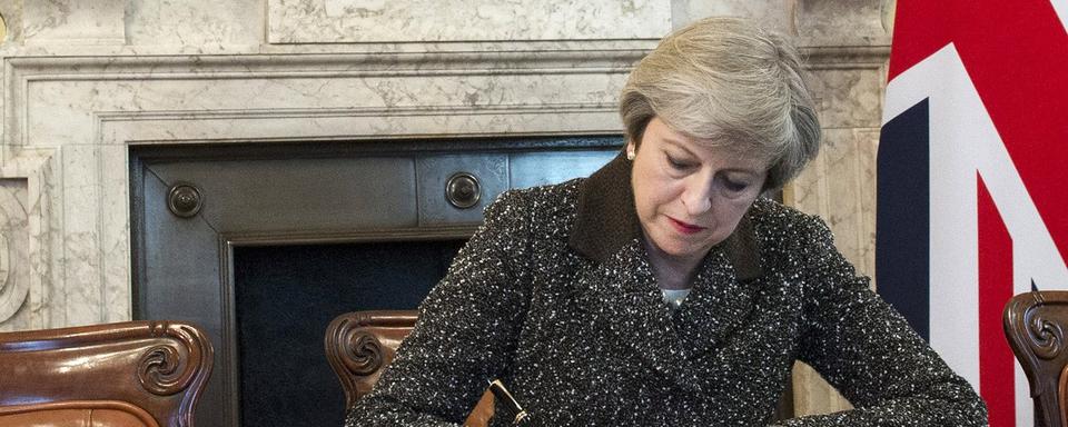 Theresa May signe la lettre déclenchant le Brexit. [EPA/Keystone - Jay Allen]