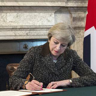 Theresa May signe la lettre déclenchant le Brexit. [EPA/Keystone - Jay Allen]