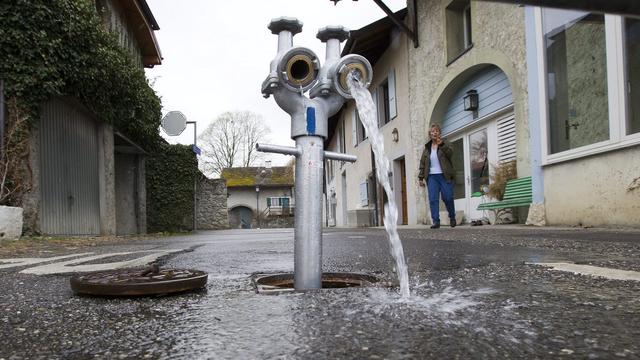 De l'eau coule d'une borne afin de purger le réseau d'alimentation en eau potable. [image d'illustration] [Keystone - Salvatore Di Nolfi]