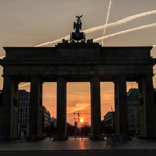 Dimanche 2 avril: le soleil se lève derrière la porte de Brandebourg, à Berlin. [DPA/Keystone - Paul Zinken]