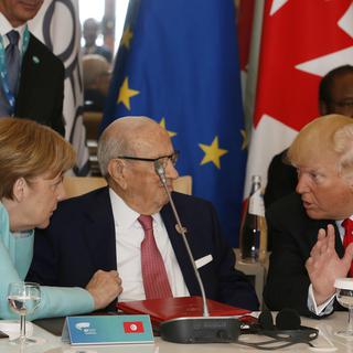 Angela Merkel en discussion avec Donald Trump. [AP/Keystone - Domenico Stinellis]