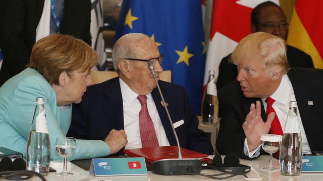 Angela Merkel en discussion avec Donald Trump. [AP/Keystone - Domenico Stinellis]