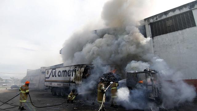 Les pompiers tentent d'éteindre un camion incendié par les narcotrafiquants à Rio, ce mardi 2 mai 2017. [EPA/LUCIANO BELFORD]