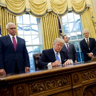 Donald Trump signant un décret dans le salon ovale de la Maison Blanche. [Saul Loeb]