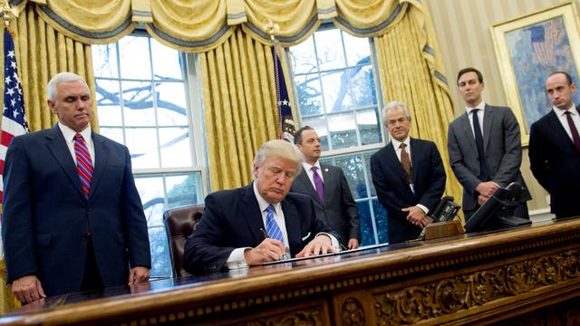 Donald Trump signant un décret dans le salon ovale de la Maison Blanche. [Saul Loeb]