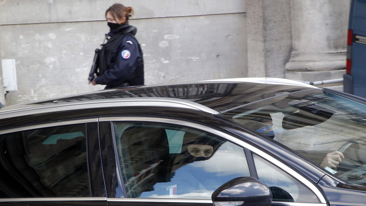 Une voiture de police sort du bâtiment de la police judiciaire à Paris. [Keystone - Michel Euler]