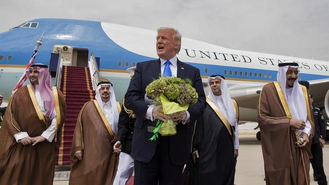 Donald Trump fleuri à son arrivée à Ryiad. A droite, le roi Salmane d'Arabie saoudite. [BANDAR AL-JALOUD / Saudi Royal Palace / AFP]