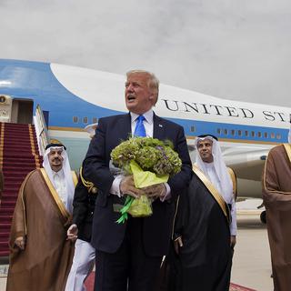 Donald Trump fleuri à son arrivée à Ryiad. A droite, le roi Salmane d'Arabie saoudite. [BANDAR AL-JALOUD / Saudi Royal Palace / AFP]