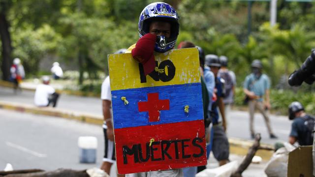 Un manifestant de l'opposition brandissant une pancarte indiquant "Pas de morts" en espagnol, durant une manifestation à Caracas. [REUTERS - Christian Veron]