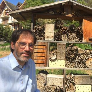 Blaise Mulhauser, Directeur du Jardin Botanique de Neuchâtel, devant l’hôtel à insectes. [Lucile Solari]