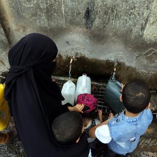 Les enfants dans les pays en conflit, comme ici au Yémen, sont quatre fois moins nombreux à bénéficier d'un approvisionnement en eau que ceux des autres pays. [Keystone - YAHYA ARHAB]