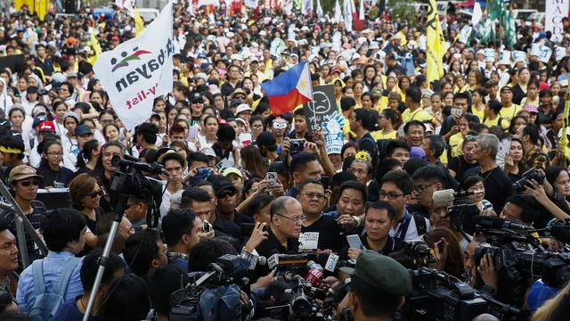 L'ancien président philippin Benigno Aquino au milieu d'une foule de protestataires à Manille le 25 février 2017. [Keystone - EPA/ROLEX DELA PENA]