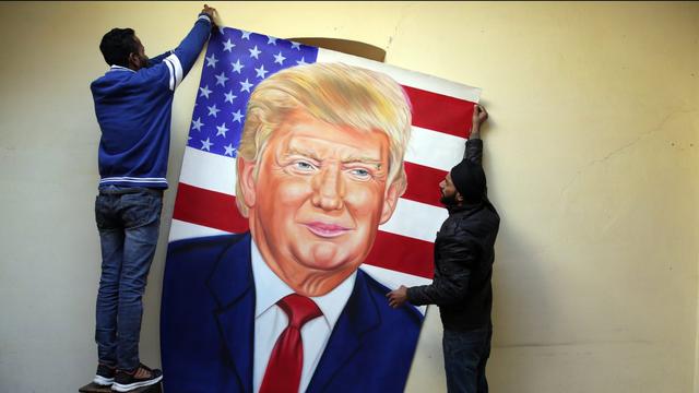L'artiste indien Jagjot Singh Rubal et son frère suspendent un portrait de Donald Trump à Washington, à la veille de la cérémonie d'investiture du président américain. [EPA/Keystone - Raminder Pal Singh]