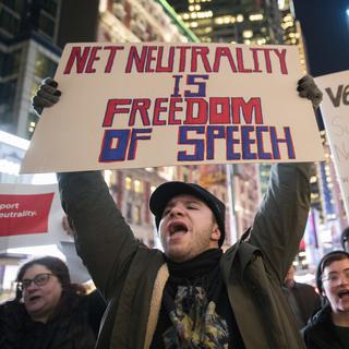 "La neutralité du net, c'est la liberté d'expression", peut-on lire sur le panneau d'un manifestant à New York, le 7 décembre 2017. [keystone - Mary Altaffer]