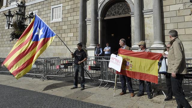Des partisans des deux camps avaient amené leurs drapeaux lundi devant la Généralité, à Barcelone. [AFP - Lluis Gene]
