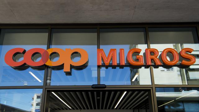 Les enseignes de Coop et Migros sur la place de la Sallaz à Lausanne. [Keystone - Jean-Christophe Bott]