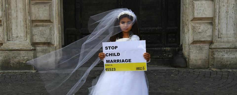 Une jeune actrice joue le rôle de Giorgia, 10 ans, forcée de marier Paolo, 47 ans, durant un happening organisé par Amnesty International pour dénoncer le mariage des enfants, à Rome en octobre 2016. [AFP - Gabriel Bouys]