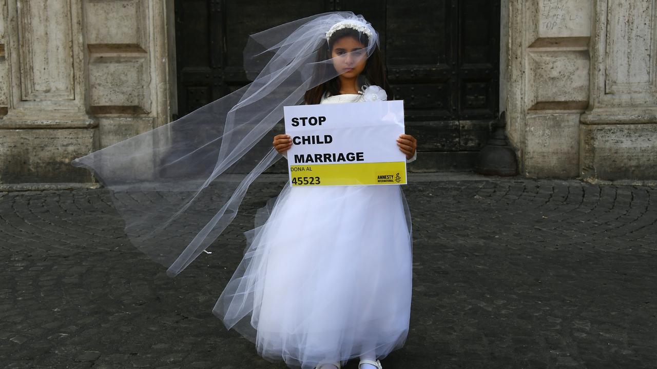 Une jeune actrice joue le rôle de Giorgia, 10 ans, forcée de marier Paolo, 47 ans, durant un happening organisé par Amnesty International pour dénoncer le mariage des enfants, à Rome en octobre 2016. [AFP - Gabriel Bouys]