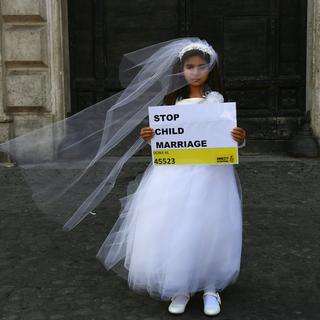 Une jeune actrice joue le rôle de Giorgia, 10 ans, forcée de marier Paolo, 47 ans, durant un happening organisé par Amnesty International pour dénoncer le mariage des enfants, à Rome en octobre 2016. [AFP - Gabriel Bouys]