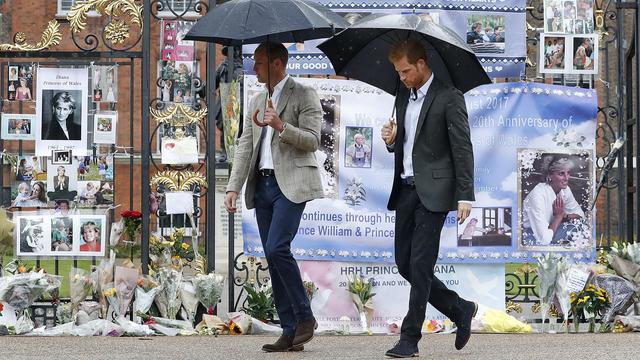 Les princes William et Harry devant les fleurs déposées devant le palais Kensington. [AP/Keystone - Kirsty Wigglesworth]