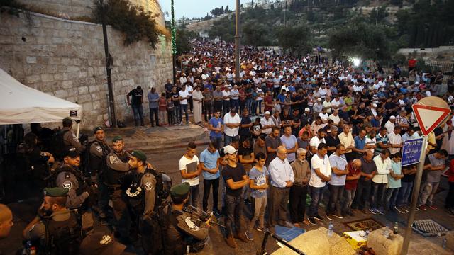 Des forces de sécurité israélienne en faction devant des Palestiniens venus protester contre les nouvelles mesures de sécurité dans la vieille-ville de Jérusalem, le 24 juillet. [AFP - Ahmad Gharabli]