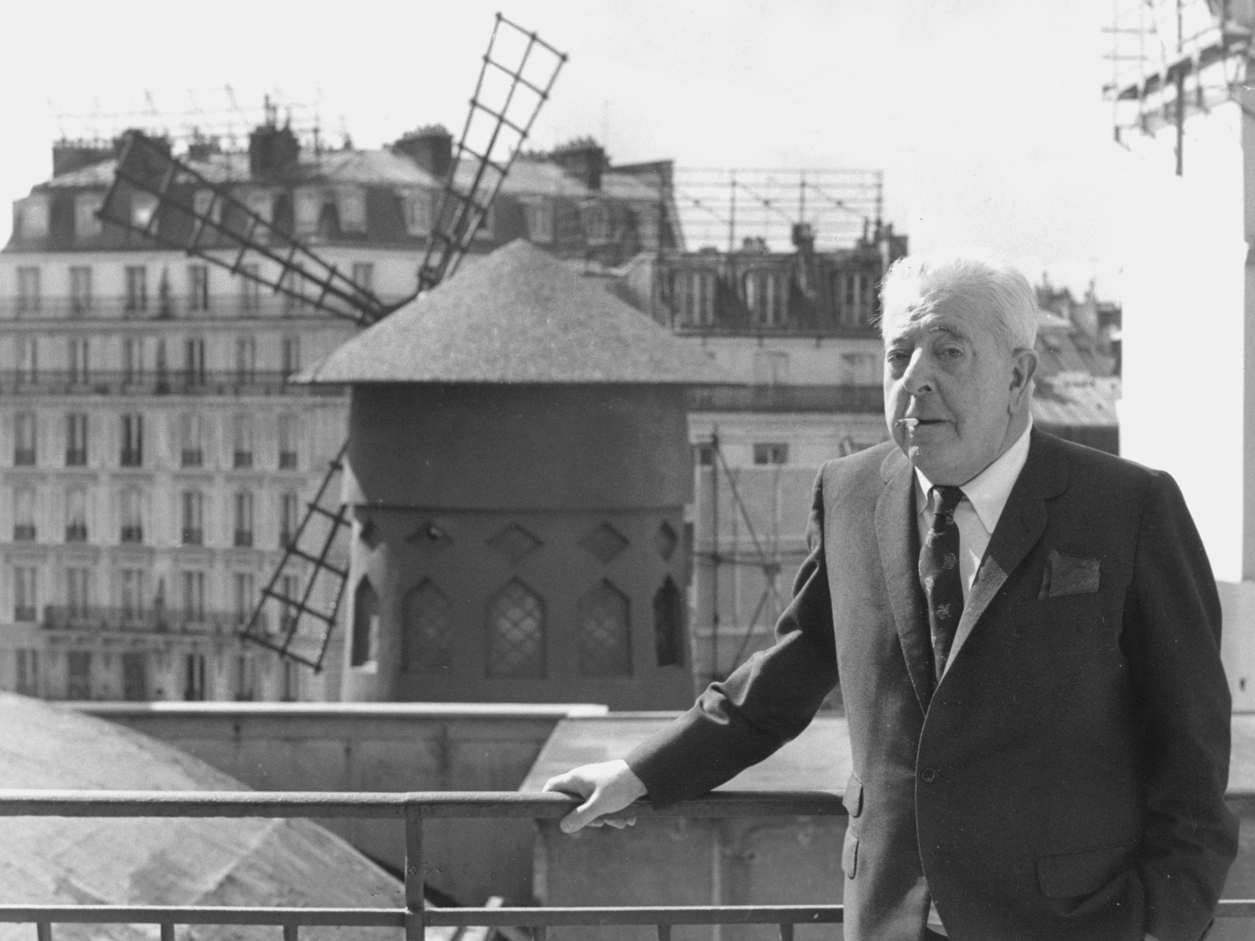 Le poète français Jacques Prévert (1900-1977), dont l'oeuvre a souvent été reprise en chanson, pose devant le Moulin Rouge à Paris, en 1977. [Getty Images - Keystone/Hulton Archive]