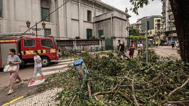 Des piétons dans les rues de Macao, après le passage du typhon Hato. [EPA/Keystone - Antonio Mil-Homens]