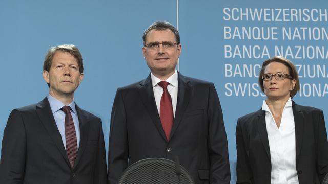 Thomas Jordan (au centre), le directeur de la BNS, entouré du vice-président Fritz Zurbrügg (à sa droite) et Andrea Maechler, membre de la direction générale (à sa gauche) lors de l'assemblée générale de la banque. [KEYSTONE - Lukas Lehmann]