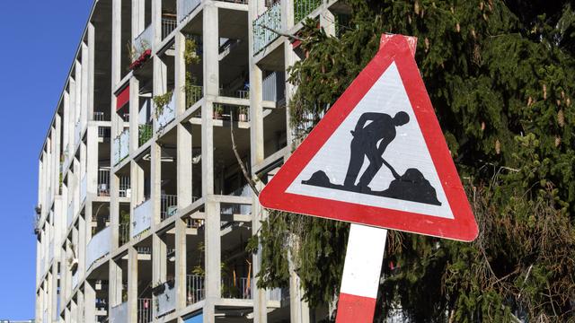 Un panneau de chantier devant l'immeuble Soubeyran, de la coopérative Equilibre, à Genève. [Keystone - Martial Trezzini]