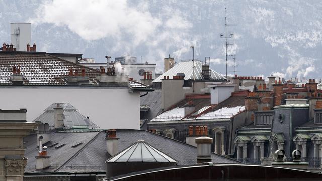 Les fumées s'échappent des cheminées sur les toits de la ville, ce lundi 18 janvier 2016 à Genève. Image d'illustration. [Keystone - Salvatore Di Nolfi]