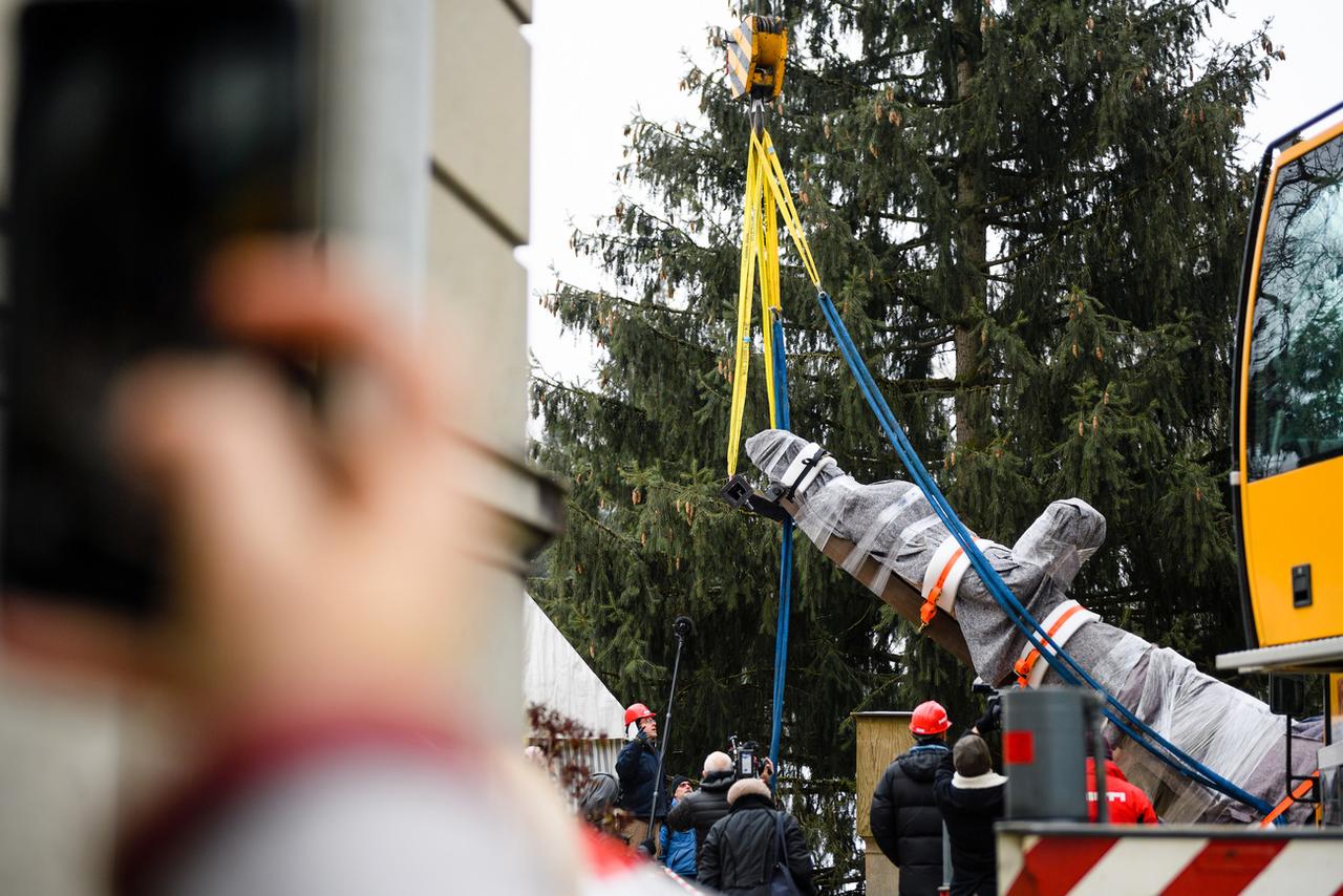 Une grue déplace une des trois statues installées devant le musée zurichois. [Keystone - Manuel Lopez]