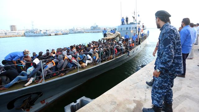 Des migrants, secourus par les garde-côtes libyens, arrivent sur une base navale à Tripoli. [Mahmud Turkia - AFP]