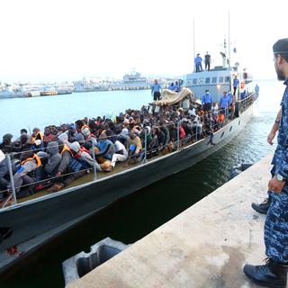 Des migrants, secourus par les garde-côtes libyens, arrivent sur une base navale à Tripoli. [Mahmud Turkia - AFP]