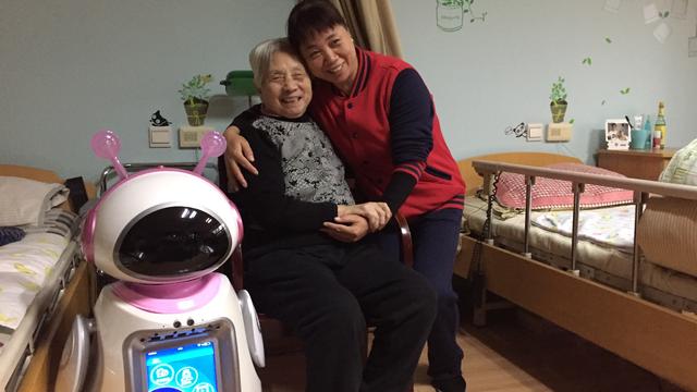 Madame Shen au centre, son infirmière et son petit robot.