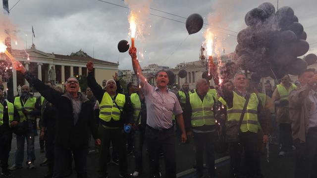 Des policiers grecs chantant des slogans devant le ministère de l'Intérieur à Athènes. [Keystone - Thanassis Stavrakis]