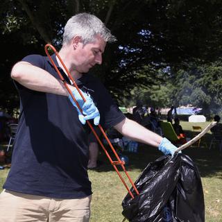Le municipal Pierre-Antoine Hildbrand lors d'une journée de sensibilisation à la question des déchets dans l'espace public. [Keystone - Christian Brun]