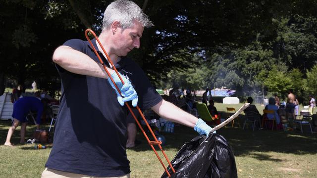 Le municipal Pierre-Antoine Hildbrand lors d'une journée de sensibilisation à la question des déchets dans l'espace public. [Keystone - Christian Brun]