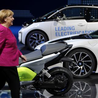 Angela Merkel devant un stand de véhicules électriques au salon de Francfort, 14.09.2017. [AP/Keystone - Michael Probst]