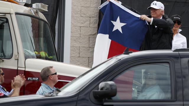 Accompagné de la first lady Melania Trump, Donald Trump a brandi un drapeau du Texas lors de sa venue dans l'Etat dévasté par les inondations. [Keystone - Evan Vucci/AP]