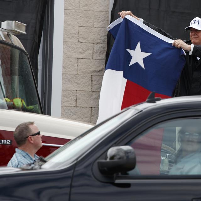 Accompagné de la first lady Melania Trump, Donald Trump a brandi un drapeau du Texas lors de sa venue dans l'Etat dévasté par les inondations. [Keystone - Evan Vucci/AP]
