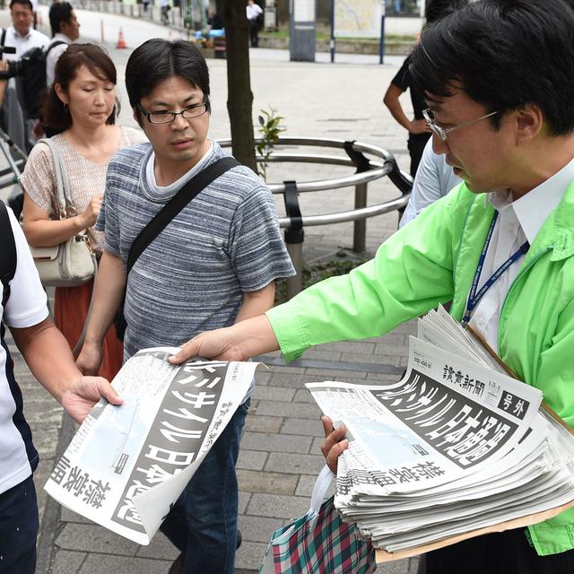 Edition spéciale d'un journal sud-coréen distribuée dans la rue après le survol du Japon par un missile nord-coréen. [Yomiuri/AFP - Masanori Inagawaki]