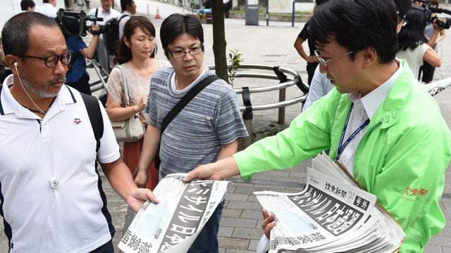 Edition spéciale d'un journal sud-coréen distribuée dans la rue après le survol du Japon par un missile nord-coréen. [Yomiuri/AFP - Masanori Inagawaki]