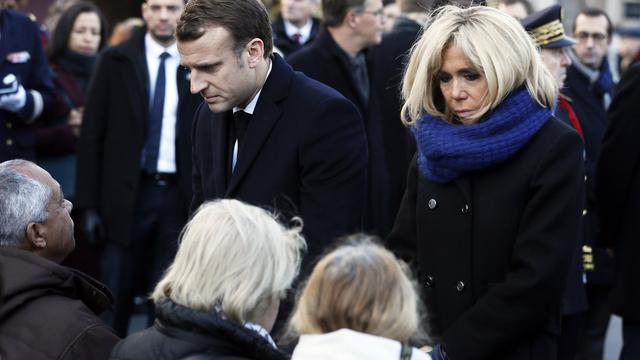 Emmanuel Macron et son épouse, lundi, aux côtés de familles de victimes à Paris. [EPA/Keystone - Etienne Laurent]