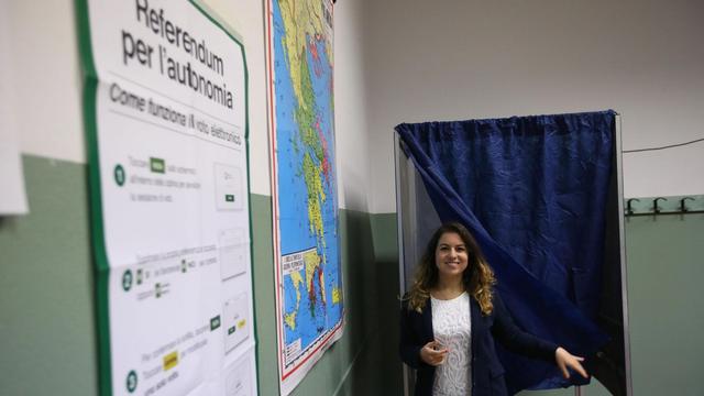 Une femme sort de l'isoloir à Brescia lors du vote le 22 octobre sur l'autonomie de la Lombardie et de la Vénétie. [EPA/FILIPPO VENEZIA]