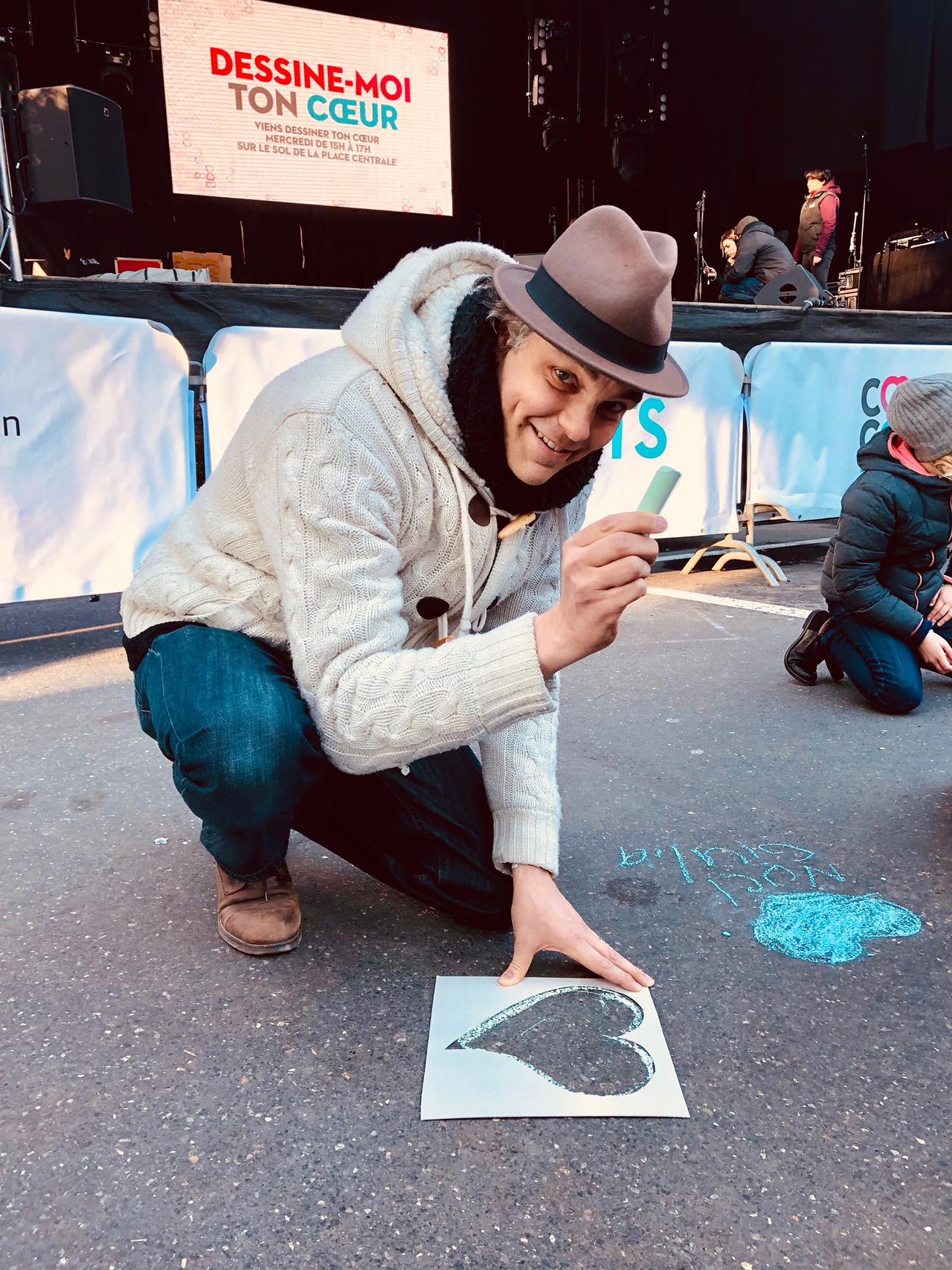 Gaëtan dessine un coeur sur la place Centrale de Lausanne, juste devant la scène de Coeur à Coeur. [RTS / DR - elo]