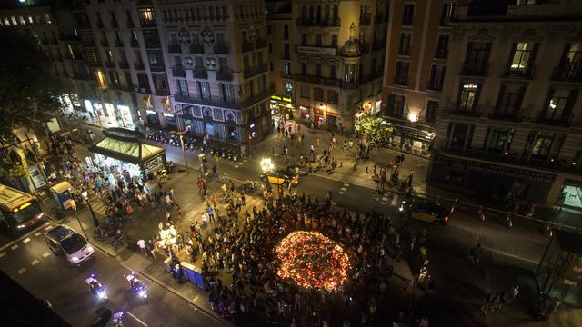 Alors que touristes et Espagnols réinvestissent les Ramblas, de nombreux autels en hommage aux victimes fleurissent. [Keystone - EPA/Quique Garcia]