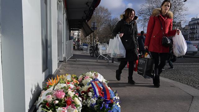 Des fleurs devant l'Hyper Casher où quatre personnes ont été tuées, pour commémorer les 2 ans de la série d'attaques commencées dans la rédaction de Charlie Hebdo. [Christophe Archambault]