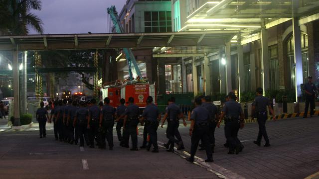 Policiers philippins se déployant vendredi aux abords de l'hôtel-casino de Manille après l'attaque de la nuit. [Citizenside/AFP - Bailey Flores]