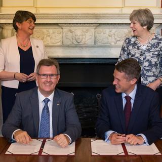Arlene Foster, leader du DUP, et Theresa May, Première ministre britannique, lors de l'accord signé à Londres le 26 juin. Au premier plan, Jeffrey Donaldson du DUP (à gauche) et le tory Gavin Williamson.